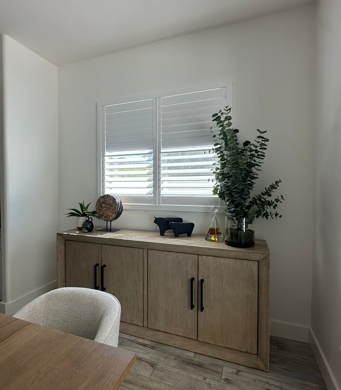 Close view of Norman Woodlore shutters above a dining room sideboard