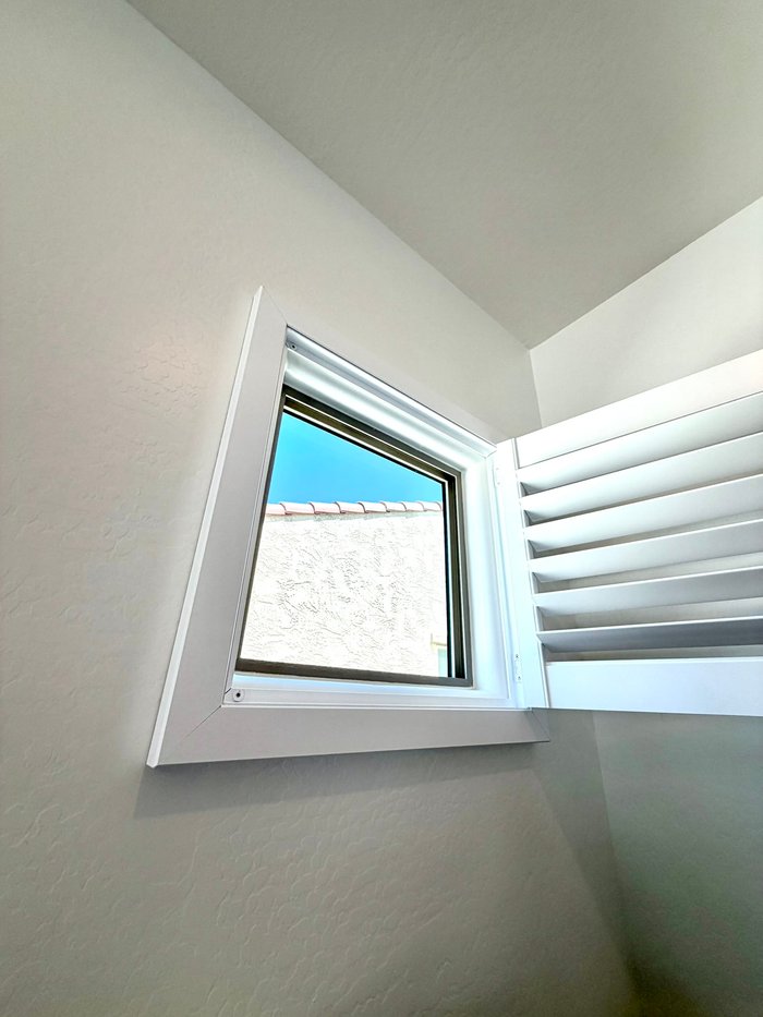 Angled specialty window fitted with a custom shutter, typical of the openings we template in Scottsdale, AZ