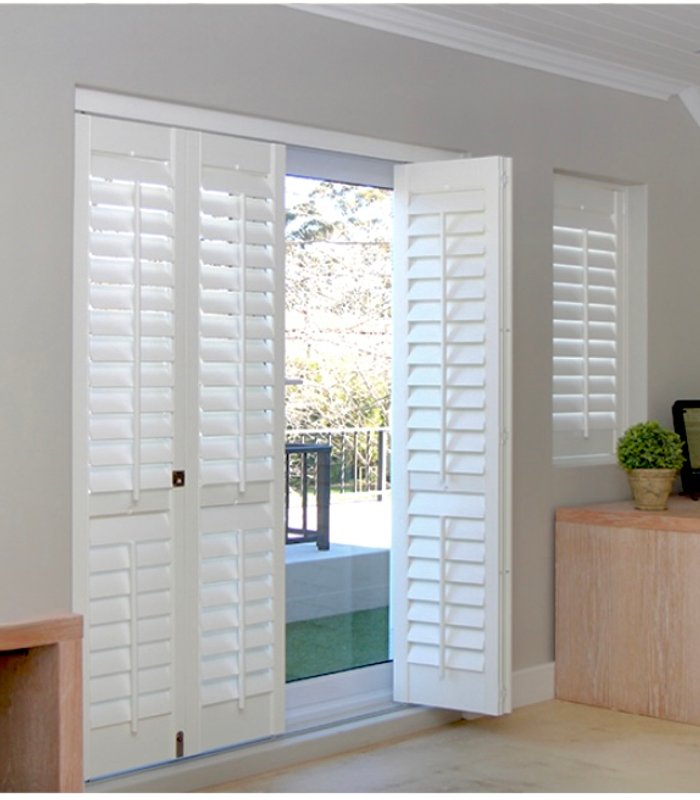 Bypass Norman shutters on a sliding patio door beside a home office