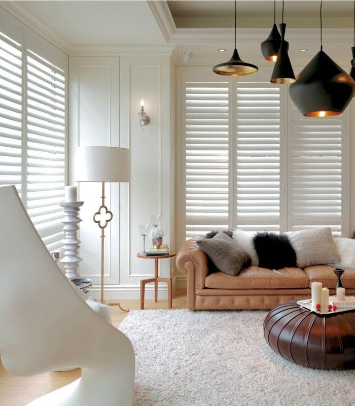 Living room with tall Norman plantation shutters and a divider rail