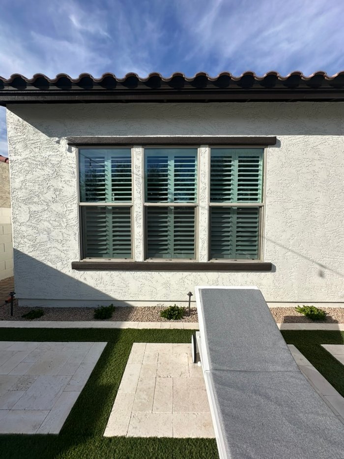 Stucco desert home exterior with plantation shutters behind the glass, a common look in Cave Creek, AZ