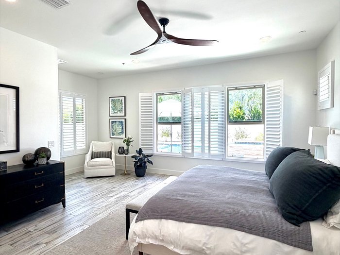 Master bedroom corner window with Norman plantation shutters and a pool view, a Gilbert, AZ install