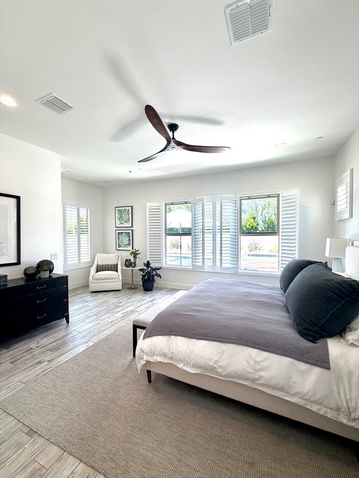 Bedroom corner window with Norman shutters overlooking a pool, a Paradise Valley, AZ style opening