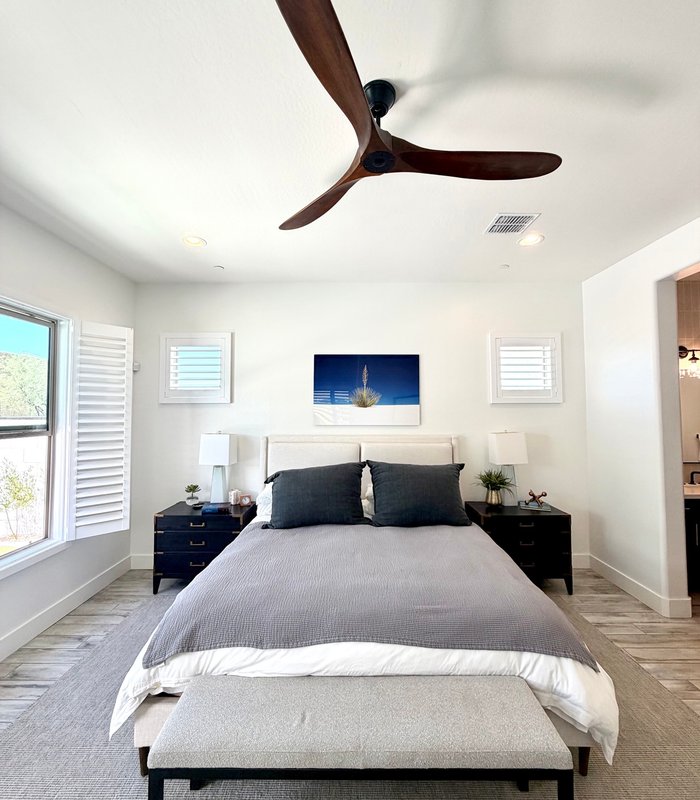 Bedroom with matching white shutters on both flanking windows