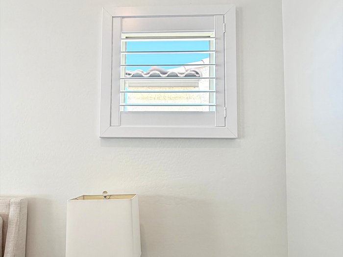 Small window fitted with a Norman shutter, the same product and finish we run through kitchens and baths in Gilbert, AZ