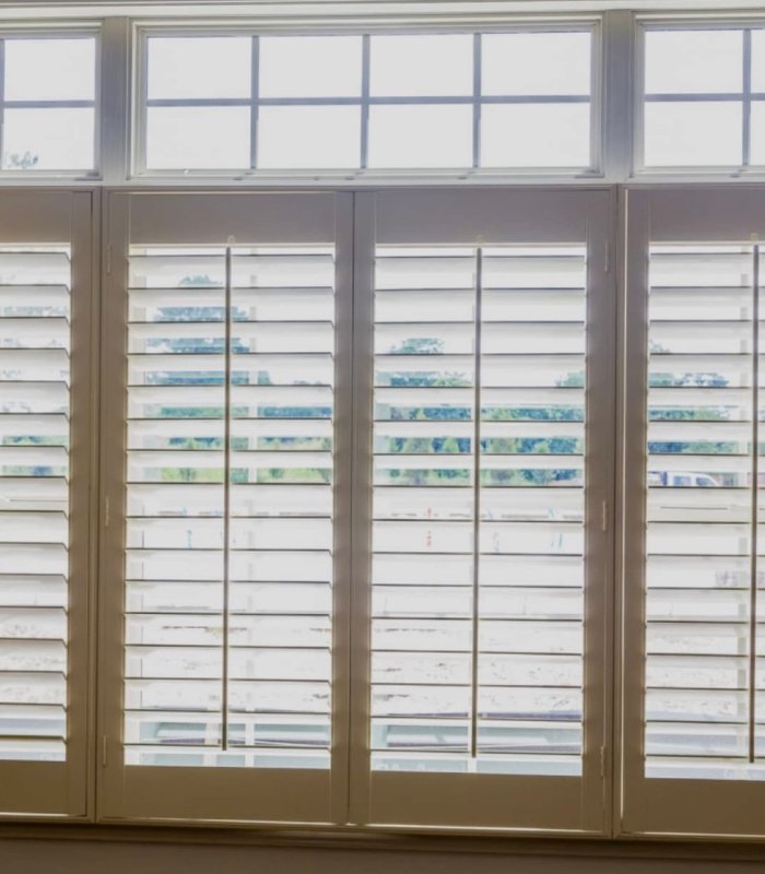 Norman shutters with a divider rail below a transom window