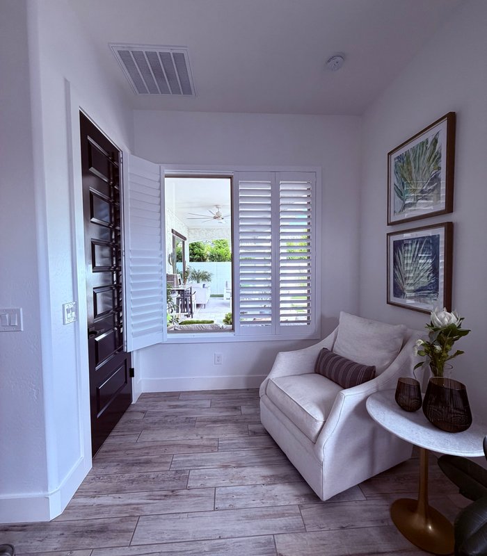 Norman shutter panels part-folded beside an entry door, opening the room to the patio