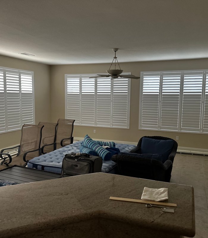 Arizona room wrapped in white plantation shutters across every window