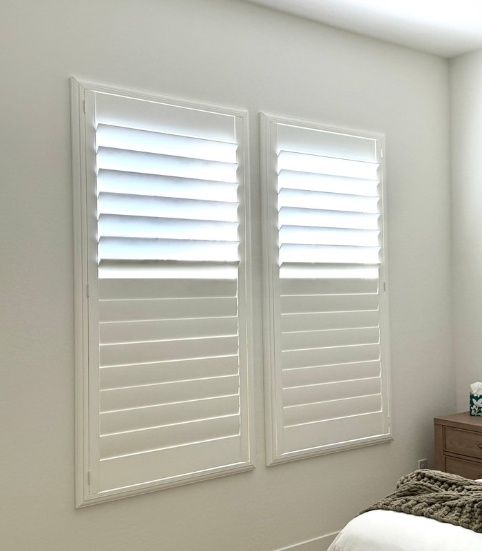 Two Norman shutter panels with a divider rail, top louvers open and bottom section closed for privacy