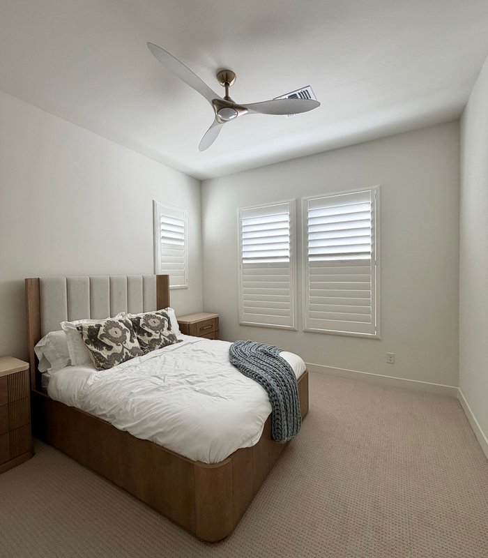 Guest bedroom with Norman Woodlore shutters on a paired window and a high side window