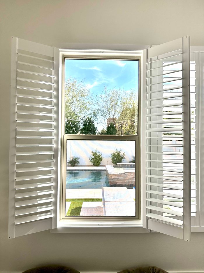 Tall window with Norman shutter panels opened wide, the two-story great-room glass common in Chandler, AZ