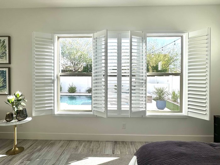Bay window with three Norman shutter panels opened to a pool view, the view-window work we do in Fountain Hills, AZ