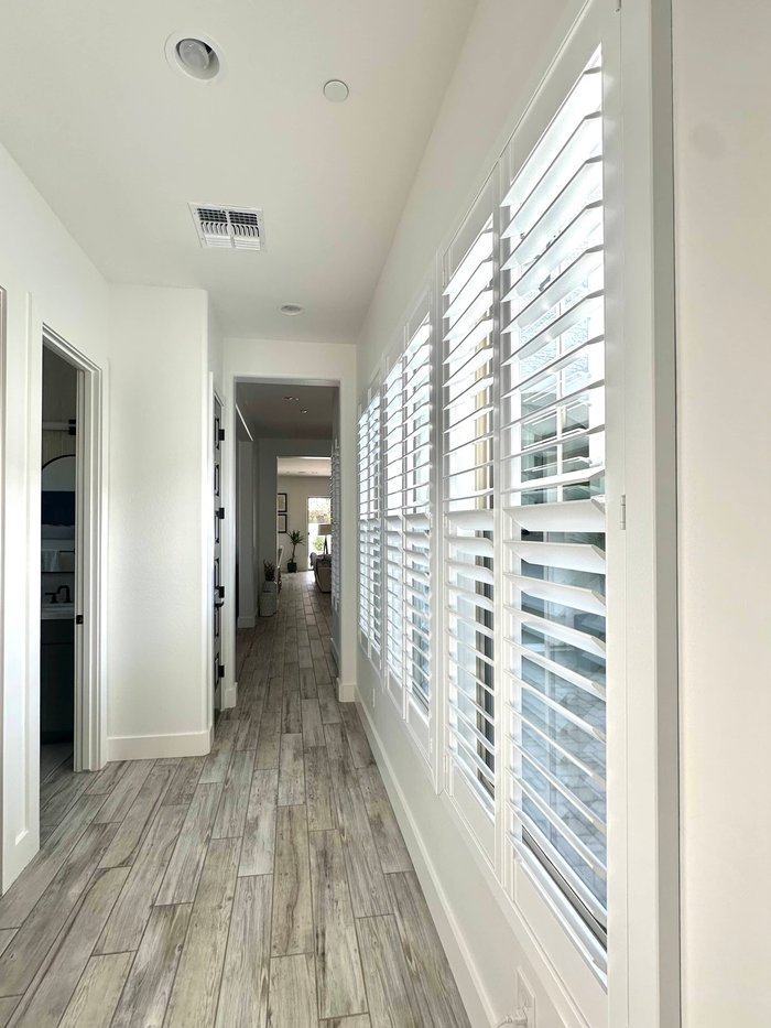 Corridor of Norman Woodlore shutters running the length of the wall in a Phoenix, AZ home