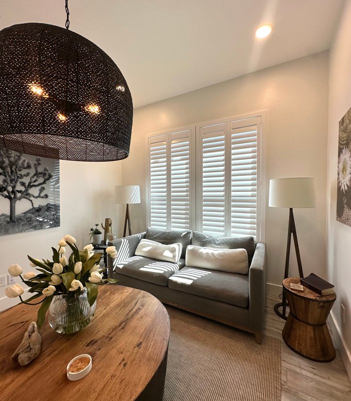 Living room with Norman Woodlore shutters filtering light across a seating area