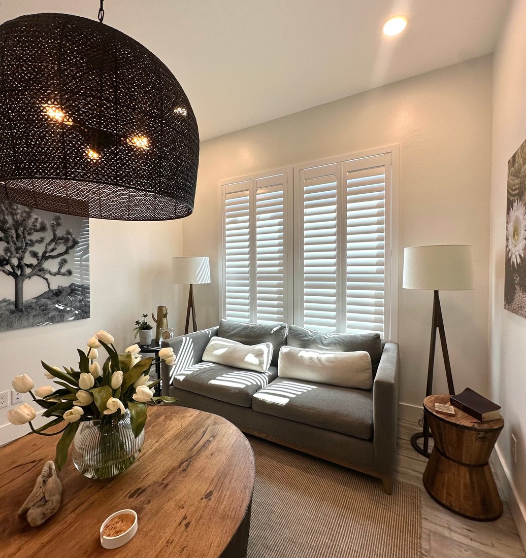 Living room with Norman Woodlore shutters filtering light across a seating area