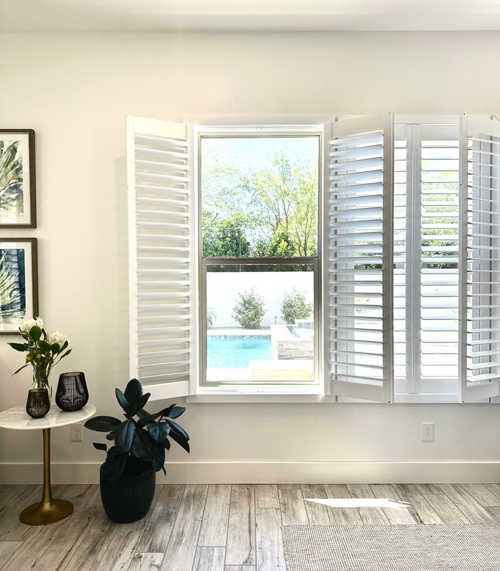 Tall window with Norman shutter panels folded back to open the room to the pool deck