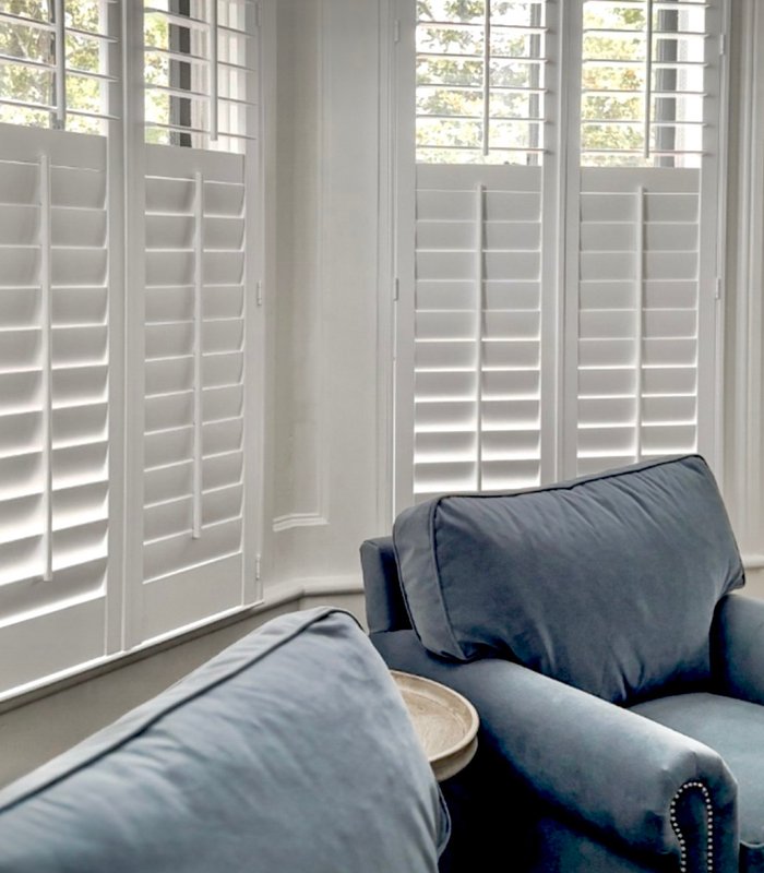 Norman plantation shutters in a bay window seating area