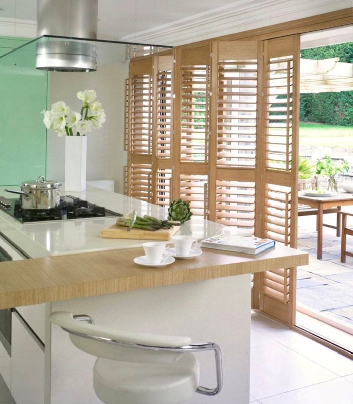 Norman shutters in a natural wood finish on a kitchen patio opening